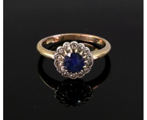 A sapphire and diamond cluster ring, the fourteen millegrain set stones in white on a yellow gold shank, stamped '18ct', size