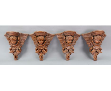 A set of four Italian pine stained as walnut wall brackets, 20th century, each carved as an infant angel mask and scrollwork 