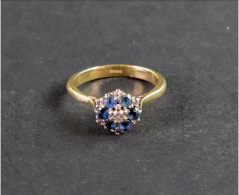 A modern 18ct gold, sapphire and diamond cluster ring, centred with a small round brilliant diamond approximately 0.22cts wit