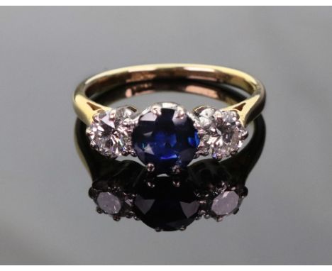 A sapphire and diamond three stone ring, centred with a round mixed-cut sapphire between round brilliant diamonds each approx