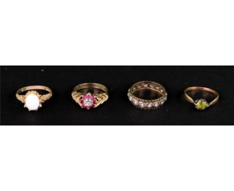 A group of four gold and gem set rings, comprising; a 9ct gold, ruby and tiny diamond cluster ring with textured leaf shoulde