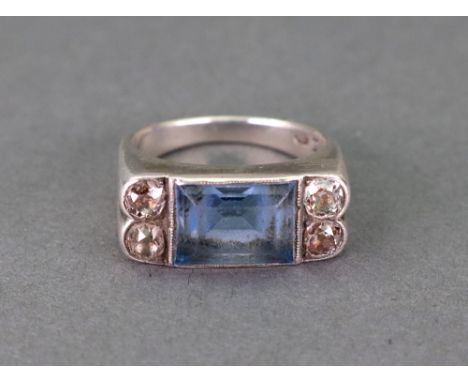 A white gold, blue topaz and diamond ring, the rectangular step cut topaz in millegrain setting, with two old cut diamonds ru