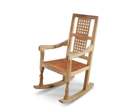 ROBERT THOMPSON OF KILBURN, A MOUSEMAN OAK ROCKING CHAIR, with typical lattice back and faceted baluster forelegs, with carve