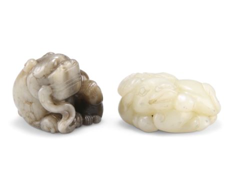 TWO CHINESE JADE CARVINGS, including A RECUMBENT BUFFALO, 2.5cm by 6cm; and A BUDDHISTIC LION GROUP, depicting an adult and y