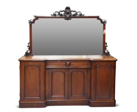 A VICTORIAN MAHOGANY FOUR-DOOR CHIFFONIER, the mirrored superstructure with foliate-carved crest, the moulded inverted breakf