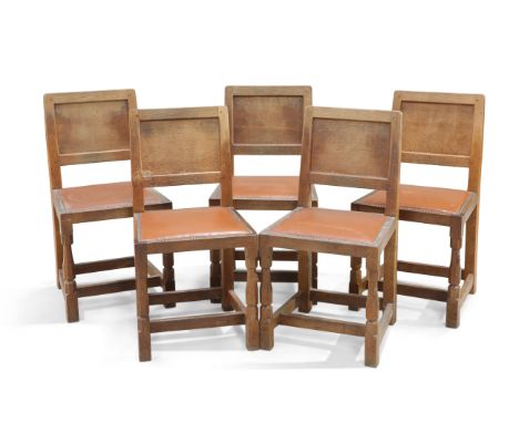 ROBERT THOMPSON OF KILBURN, A SET OF FIVE MOUSEMAN OAK DINING CHAIRS, each with adzed panel back and faceted baluster legs te