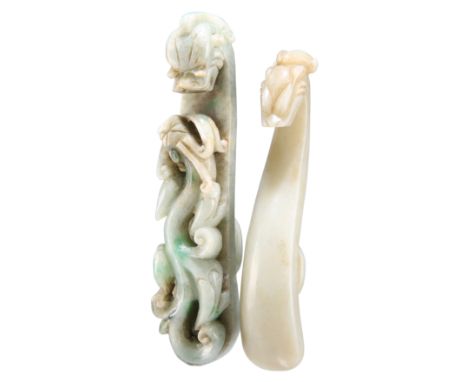 TWO CHINESE CARVED JADE BELT HOOKS, each with dragon head terminals, one having a carved dragon shaft. (2) 9cm-10cm longCONDI
