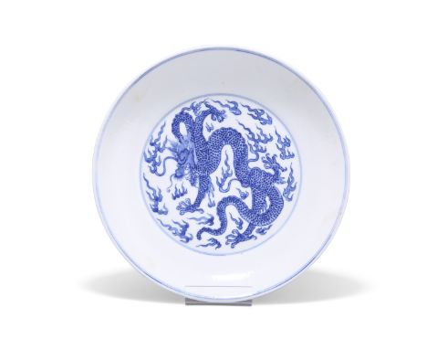 A CHINESE BLUE AND WHITE 'DRAGON' DISH, the interior painted with a curled dragon amongst thunder bolts, the exterior with tw