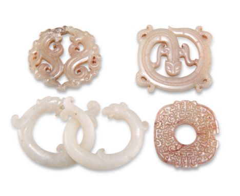 FOUR CHINESE CARVED JADE PENDANTS, including A PENDANT FORMED OF TWO INTERLOCKING RINGS AS A DRAGON AND A PHOENIX; TWO EXAMPL
