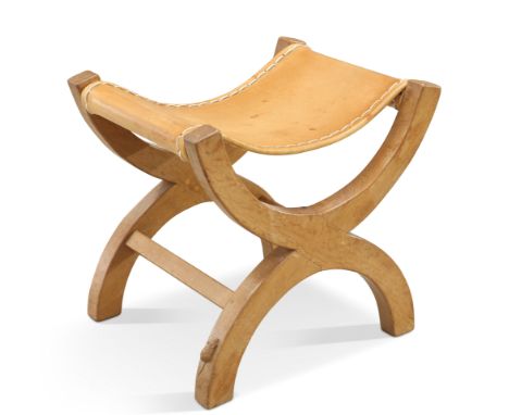 ROBERT THOMPSON OF KILBURN, A MOUSEMAN OAK STOOL, of rounded X-form, with slung leather seat, adzed throughout, with carved m