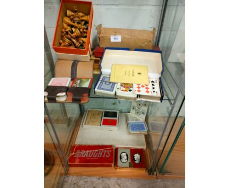 2 shelf of playing cards , chess set with boards etc . 