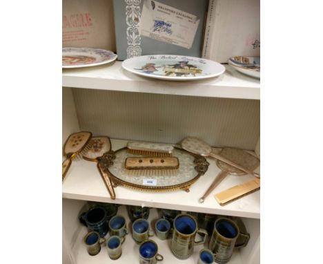 Shelf of petite point dressing table items . 