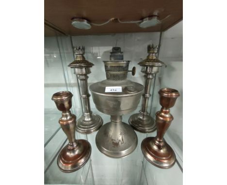 Shelf of plated candle sticks together with oil lamp.. 