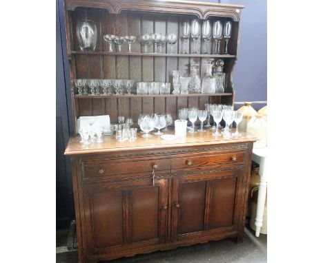 A 20th Century Oak Welsh Dresser, carved pelmet with two shelves, two drawers (one with cutlery inserts) and a twin door cabi