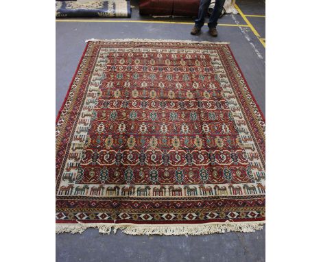 A large Persian carpet in a burgundy field with geometric decoration and stylised donkey border. 310cm x 226cm 