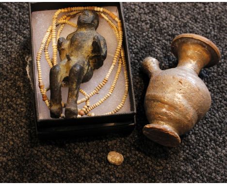 A small Mycenaean style pottery flask, a cast metal figure, a small carved stone and a string of beads. 