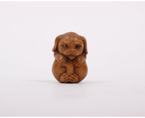 A small wooden carved Netsuke of a dog.