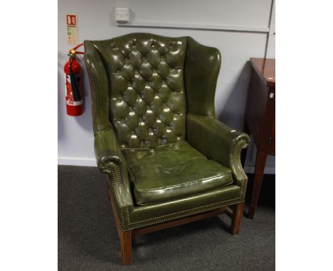 A pair of reproduction Georgian style wing back armchairs, with stud &amp; button detail, upholstered in faux green leather, 