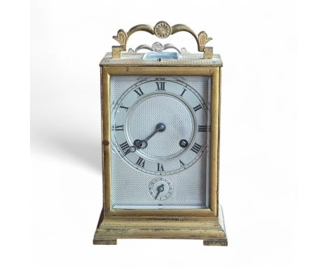 An early 20th century engine turned carriage clock, the silvered dial with Roman numerals and subsidiary dial beneath, striki