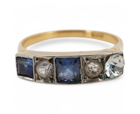 A sapphire ring, early 20th century, set with two square step-cut sapphires, spaced by pastes, mounted in gold, size O, stamp