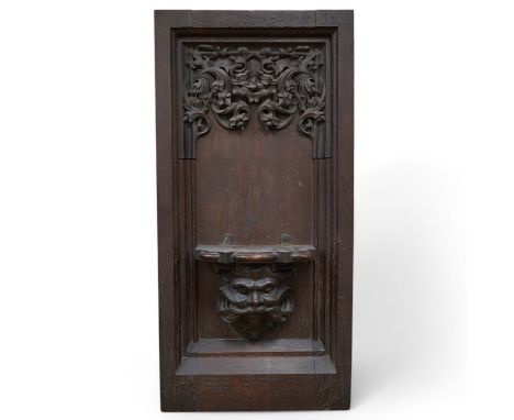 A 19th century Gothic revival carved oak wall bracket carved with Gothic tracery and the head of Moses, height 86cm, width 41