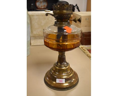 A vintage oil burning light or lamp base with glass well and brass base