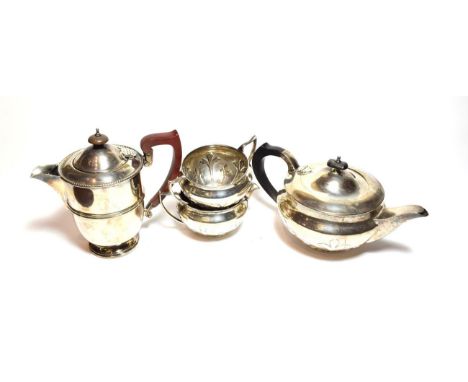 A three-piece George V silver tea-service, Sheffield, 1932, each piece applied with foliage, comprising a teapot, with wood h