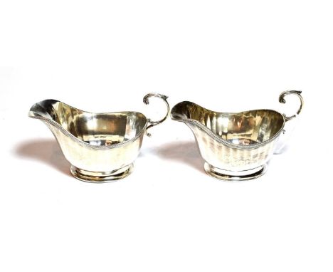 A pair of George V silver sauce boats, by James R. Ogden and Sons Ltd., Birmingham, 1934, each fluted oval and on spreading f