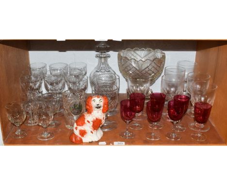 A large cut glass pedestal bowl, decanter and stopper, various wine glasses and seven cranberry glass examples, together with