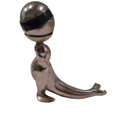 A 1950s/60s chrome ash tray table lighter, formed as a seal holding ball, 16cm high, 14cm wide.