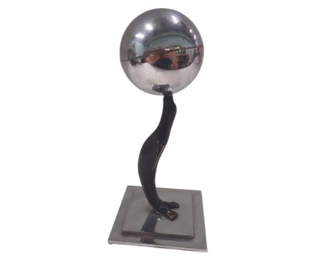 An Art Deco style table lighter, in chrome finish, formed as a seal with orb, on square stepped base, 15cm high, 8cm x 8cm ba