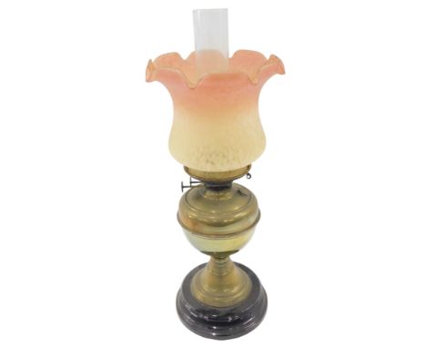 A Victorian brass oil lamp, the pink and yellow mottled shade, on a plain brass stem, on ebonised circular black foot, 58cm h