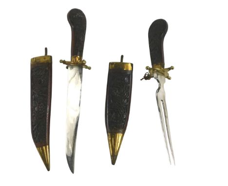 A Burmese dagger and fork set, with carved sheaths and grips, brass mounted, 33cm long overall.&nbsp;