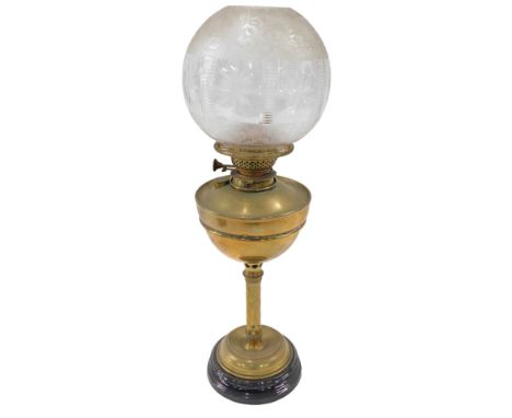 A Victorian brass oil lamp, the clear glass etched floral shade, on a brass reservoir and hatch stem, on a circular ebonised 