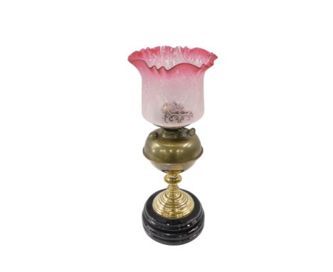 A Victorian brass oil lamp, the later pink cranberry glass shade with floral engraved decoration, on plain brass body, with e