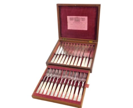 A set of twelve Victorian dessert knives and forks, with mother of pearl handles, in fitted mahogany case, with pink velvet l