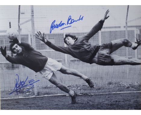 Peter Shilton and Gordon Banks Signed Football Print depicting both diving for the ball black and white, measures 4x30cm appr