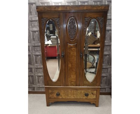 VICTORIAN WALNUT WARDROBEenclosed by two upright oval bevelled mirror doors, long drawer below, on bracket feet, 116 cm wide