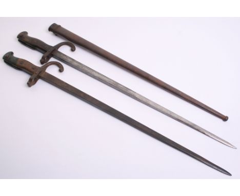 Two French Gras Bayonets, one complete with its original metal scabbard. Some staining and wear to the blades and fittings. 