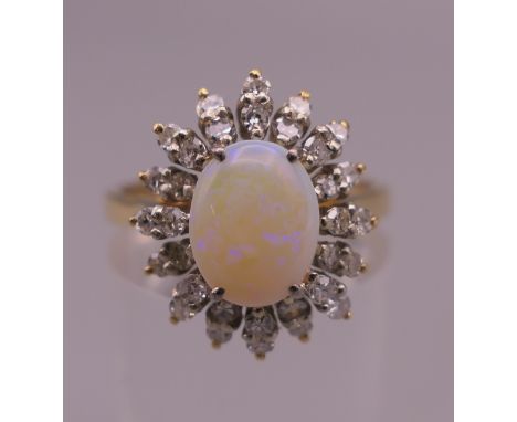 An 18 ct gold opal and diamond cluster ring. Ring size O. 4.9 grammes total weight.