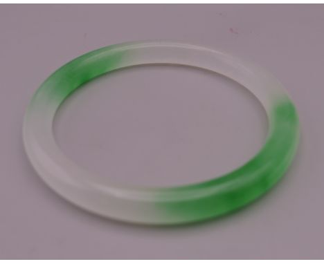 A two tone jade bangle. 7 cm exterior diameter and 5.75 cm interior diameter.