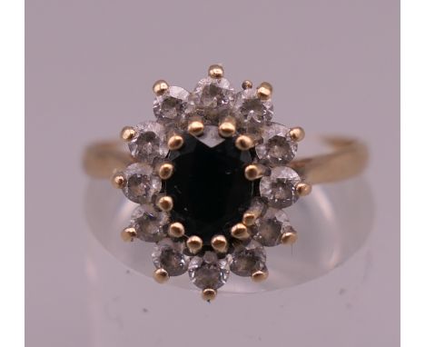 A 9 ct gold sapphire and clear stone ring. Ring size P. 2.5 grammes total weight.