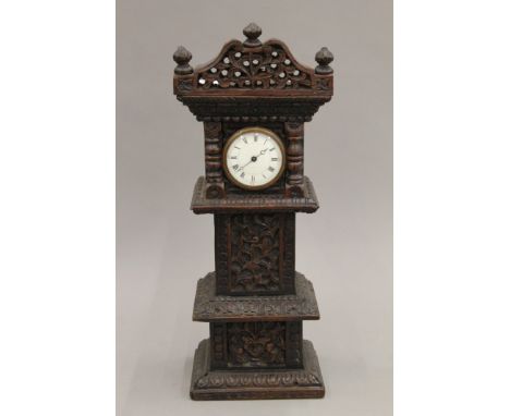 A carved miniature longcase clock. 40 cm high.