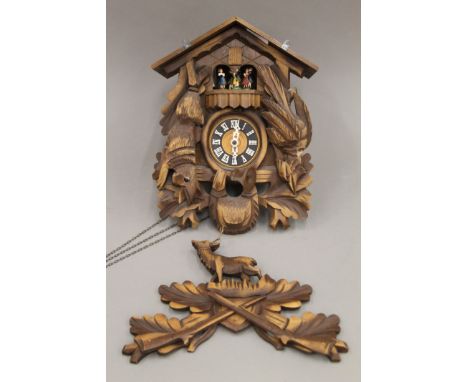 A Blackforest cuckoo clock with roundabout. Approximately 49 cm high.