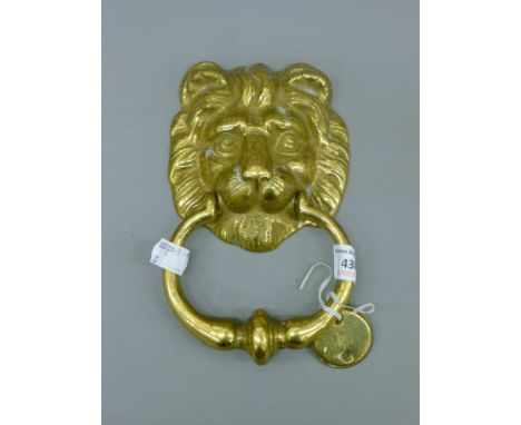 A brass lion mask door knocker. 19 cm high.