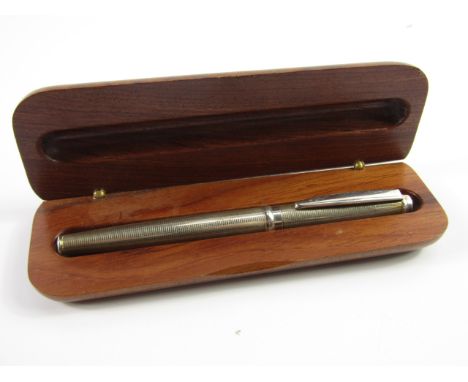 A silver cased cartridge pen, with engine turned decoration, wooden boxed.