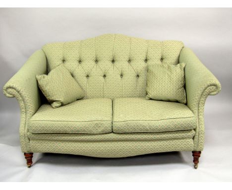 A Victorian style two seater sofa, and matching scroll armchair in green and cream shell upholstery.