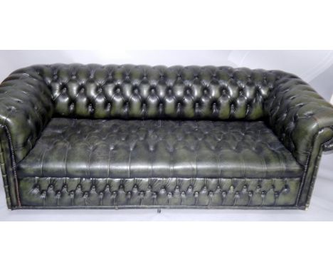 A green buttoned leather Chesterfield sofa.