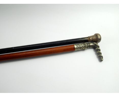 A silver topped ebony walking stick, 85cm long, and a malacca cane with a plated handle cast with a serpent and chased with f