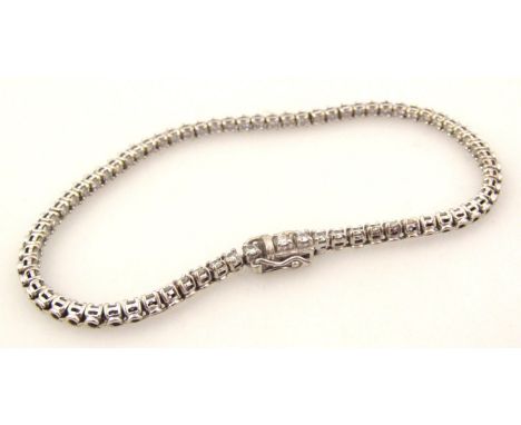 An 18ct white gold tennis bracelet, set with an arrangement of uniform diamonds, claw set with gate clasp, 20cm long, 10g all